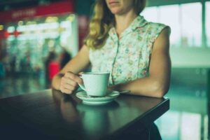 mujer toma café en el aeropuerto