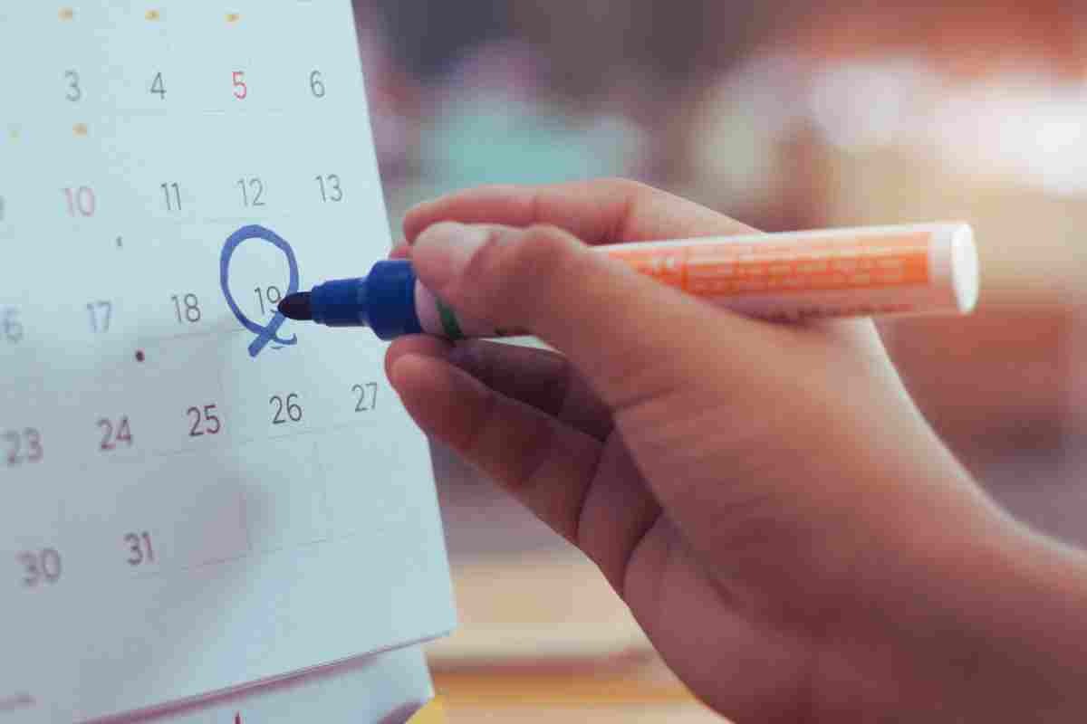 mano che cerchia un giorno nel calendario