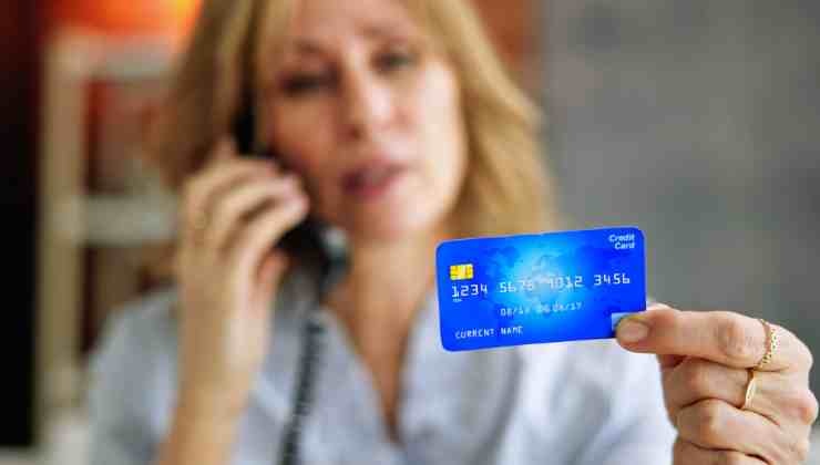 mujer al telefono con tarjeta
