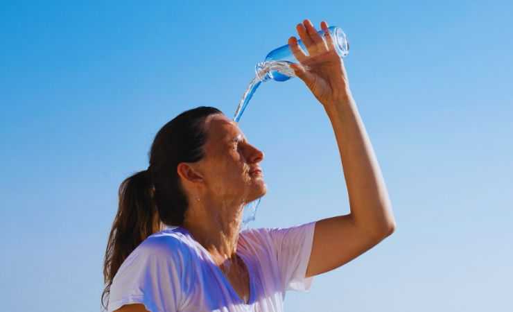 niña se echa agua en la cabeza