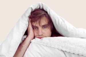 hombre cansado en la cama